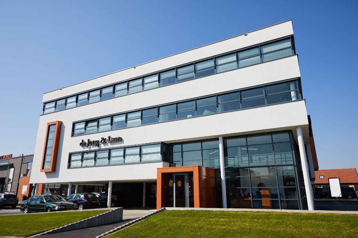 Het pand van de Jong & Laan in vestiging Elst is een wit gebouw met drie verdiepingen en vele ruiten