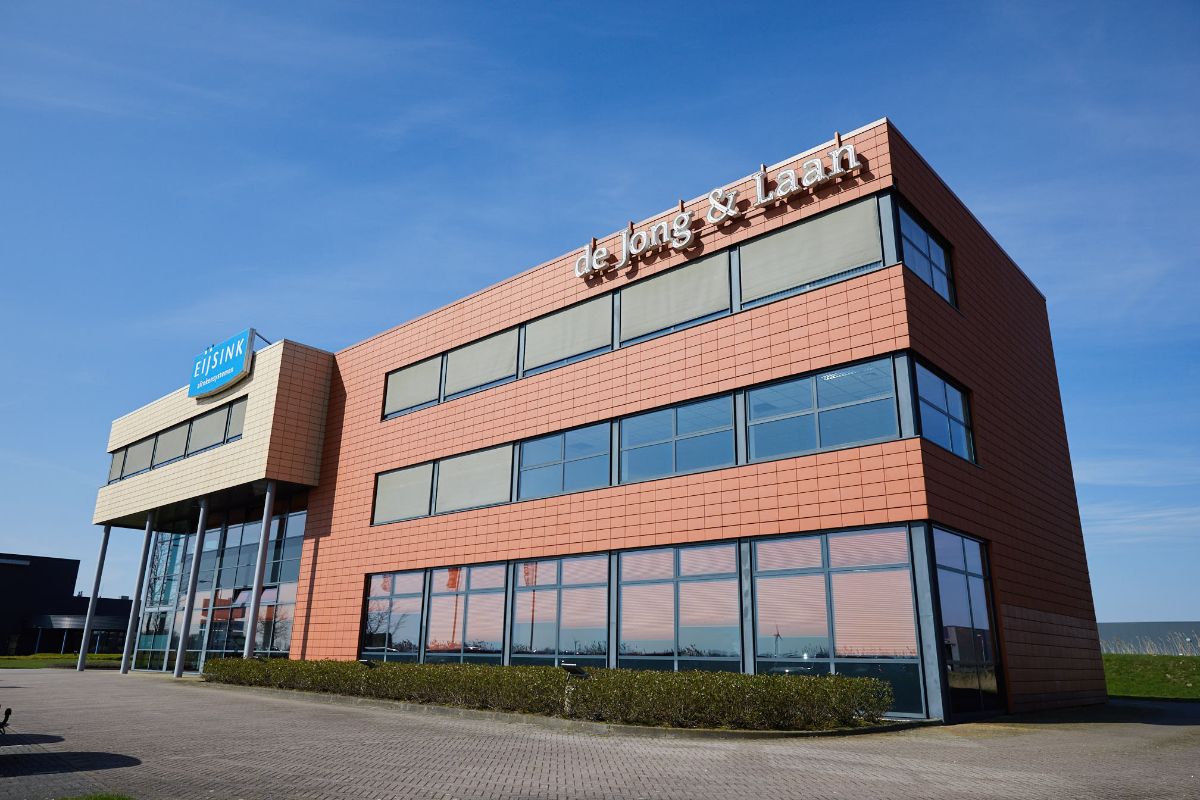 Dit bruine gebouw omgeven door een heldere blauwe lucht is het pand van de Jong & Laan Emmeloord 